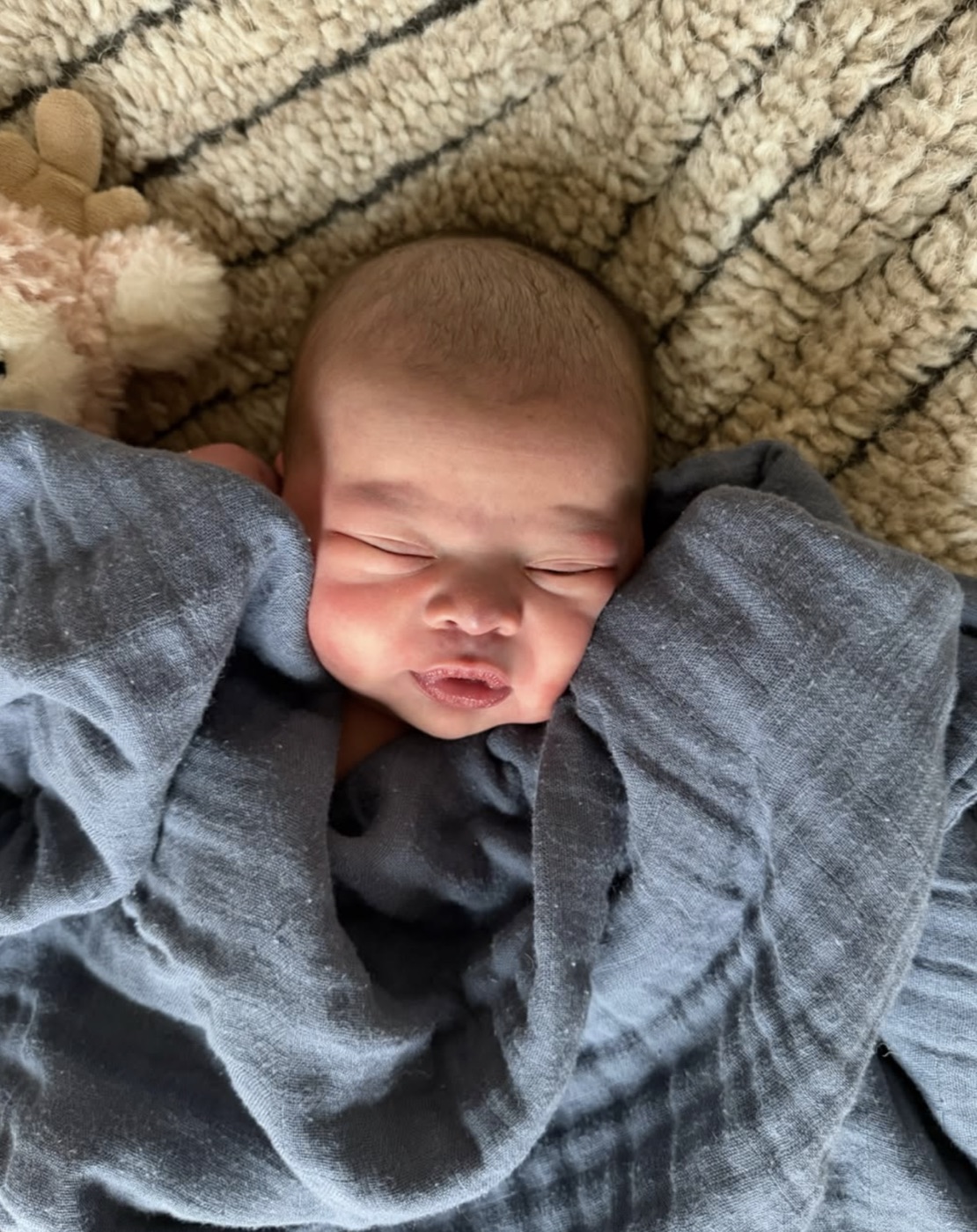 Kara's newborn baby sleeping, wrapped in a blanket